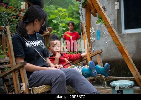 (230707) -- GONGSHAN, 7 juillet 2023 (Xinhua) -- Li Miao'en, volontaire, parle avec un enfant à la bibliothèque 'Banshan Huayu' dans le village de Qiunatong, dans le canton de Bingzhongluo dans le comté autonome de Gongshan Dulong et nu, préfecture autonome de Lisu de Nujiang, province du Yunnan, au sud-ouest de la Chine, 5 juillet 2023. La rivière Nujiang, descendant des montagnes Tanggula sur le plateau Qinghai-Tibet, se fraie un chemin à travers les majestueuses montagnes du Yunnan où se forme un magnifique canyon. Niché à la pointe nord du canyon de la rivière Nujiang est le village de Qiunatong, qui abrite une bibliothèque unique ca Banque D'Images