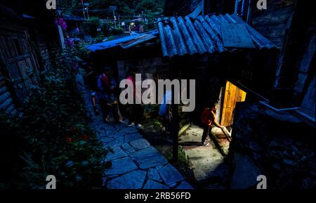 (230707) -- GONGSHAN, 7 juillet 2023 (Xinhua) -- les enfants entrent à la bibliothèque 'Banshan Huayu' dans le village de Qiunatong, dans la municipalité de Bingzhongluo, dans le comté autonome de Gongshan Dulong et nu, préfecture autonome Lisu de Nujiang, province du Yunnan, dans le sud-ouest de la Chine, le 5 juillet 2023. La rivière Nujiang, descendant des montagnes Tanggula sur le plateau Qinghai-Tibet, se fraie un chemin à travers les majestueuses montagnes du Yunnan où se forme un magnifique canyon. Niché à l'extrémité nord du canyon de la rivière Nujiang se trouve le village de Qiunatong, qui abrite une bibliothèque unique appelée 'Banshan Huayu' (demi-H Banque D'Images