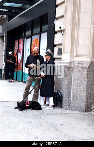 Un couple avec un chien d'assistance Banque D'Images