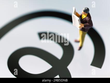 Ankara-Turquie:07 juillet 2023 : figurine d'homme lisant le journal tout en se tenant debout sur le logo de l'application threads sur l'écran. La nouvelle application de médias sociaux par Meta. Banque D'Images