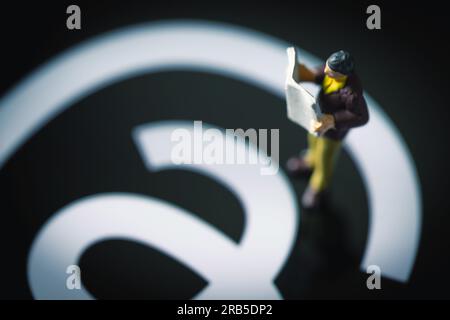 Ankara-Turquie:07 juillet 2023 : figurine d'homme lisant le journal tout en brandissant sur le logo de l'application threads à l'écran. La nouvelle application de médias sociaux par Meta Pla Banque D'Images