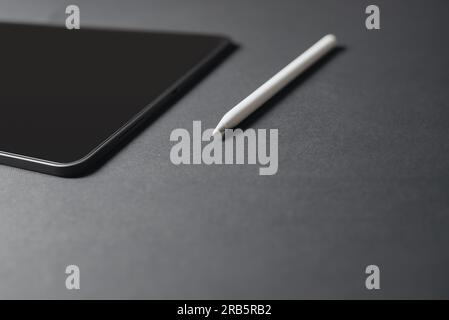 Gros plan d'une tablette et d'un crayon sur fond gris Banque D'Images