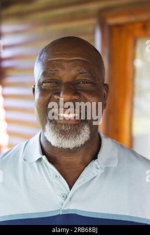 Portrait de l'homme afro-américain senior heureux contre la maison. Style de vie senior, détente, retraite et bien-être dans la nature, inchangé. Banque D'Images