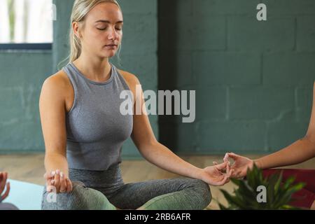 Femme caucasienne pratiquant le yoga sur tapis en studio. Yoga, exercice, fitness et mode de vie sain, inchangés. Banque D'Images