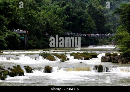 ANSHUN, CHINE - 7 JUILLET 2023 - les touristes se rafraîchissent en jouant dans l'eau devant la cascade Huangguoshu à Anshun, province du Guizhou, Chine, le 7 juillet Banque D'Images