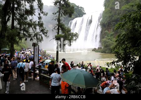 ANSHUN, CHINE - 7 JUILLET 2023 - les touristes se rafraîchissent en jouant dans l'eau devant la cascade Huangguoshu à Anshun, province du Guizhou, Chine, le 7 juillet Banque D'Images