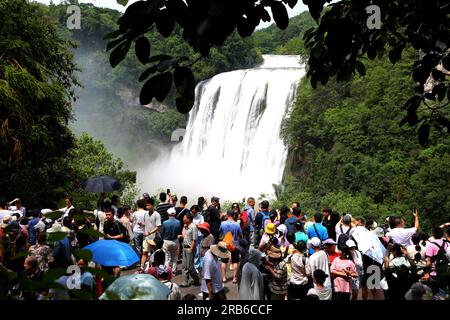 ANSHUN, CHINE - 7 JUILLET 2023 - les touristes se rafraîchissent en jouant dans l'eau devant la cascade Huangguoshu à Anshun, province du Guizhou, Chine, le 7 juillet Banque D'Images