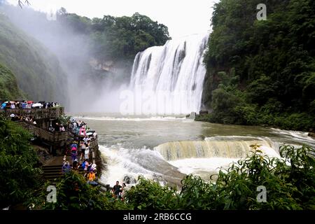 ANSHUN, CHINE - 7 JUILLET 2023 - les touristes se rafraîchissent en jouant dans l'eau devant la cascade Huangguoshu à Anshun, province du Guizhou, Chine, le 7 juillet Banque D'Images