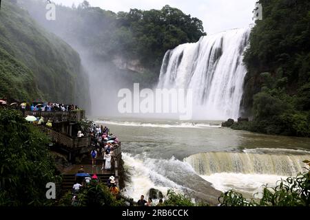 ANSHUN, CHINE - 7 JUILLET 2023 - les touristes se rafraîchissent en jouant dans l'eau devant la cascade Huangguoshu à Anshun, province du Guizhou, Chine, le 7 juillet Banque D'Images