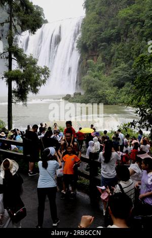 ANSHUN, CHINE - 7 JUILLET 2023 - les touristes se rafraîchissent en jouant dans l'eau devant la cascade Huangguoshu à Anshun, province du Guizhou, Chine, le 7 juillet Banque D'Images