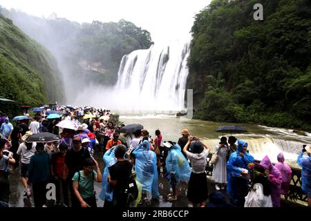 ANSHUN, CHINE - 7 JUILLET 2023 - les touristes se rafraîchissent en jouant dans l'eau devant la cascade Huangguoshu à Anshun, province du Guizhou, Chine, le 7 juillet Banque D'Images