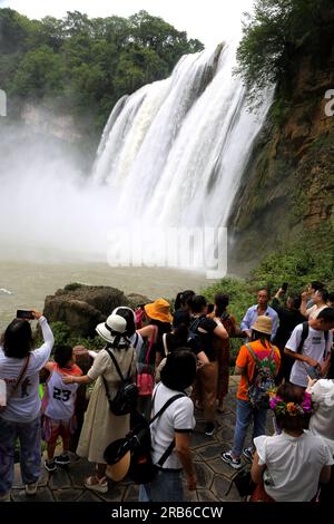 ANSHUN, CHINE - 7 JUILLET 2023 - les touristes se rafraîchissent en jouant dans l'eau devant la cascade Huangguoshu à Anshun, province du Guizhou, Chine, le 7 juillet Banque D'Images