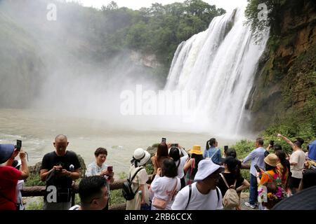 ANSHUN, CHINE - 7 JUILLET 2023 - les touristes se rafraîchissent en jouant dans l'eau devant la cascade Huangguoshu à Anshun, province du Guizhou, Chine, le 7 juillet Banque D'Images