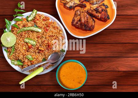 Riz frit au poulet et poulet tandoori sur fond en bois. Banque D'Images