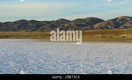 Lac Soda blanc sec avec des montagnes en arrière-plan sous le ciel bleu. Banque D'Images