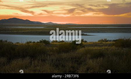 Blanc sec Soda Lake et collines sous le ciel rouge du coucher de soleil. Banque D'Images