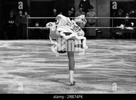 New York, New York : 8 février 1937 Melitta Brunner, patineuse artistique viennoise, effectue une danse solo à l'étang de patinage du Rockefeller Center pour le fonds de la Croix-Rouge pour les victimes des inondations. C'est son premier voyage aux États-Unis. Banque D'Images