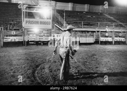 McAlester, Oklahoma : septembre. 1971 Un prisonnier cow-boy traverse l'arène vide portant son trophée qui rejoindra les deux autres qu'il expose dans sa cellule. Banque D'Images