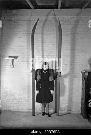 Californie : c. 1925 Une femme debout tenant une paire de skis extraordinairement longs. Banque D'Images