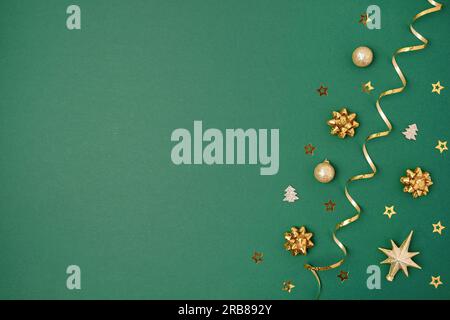 Fond vert nouvel an. Décoration dorée. Maquette de carte de vœux de Noël. Boules brillantes. Vue de dessus, espace de copie. Boules d'or, confetti sur la purée de pommes de terre Banque D'Images