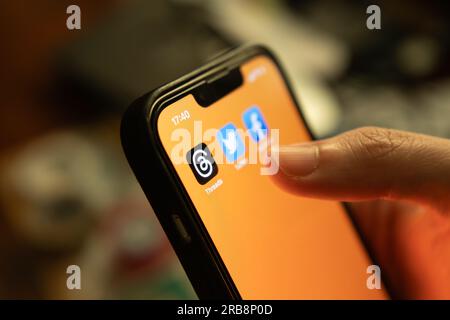 Bangkok, Thaïlande - 8 juillet 2023 : iPhone 13 montrant son écran avec des fils, une application de médias sociaux en ligne de Meta, des icônes. Banque D'Images