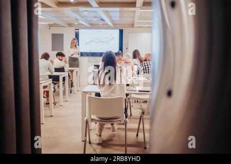 Les gens d'affaires multiculturels ayant la formation en classe, apprenant la croissance des profits, discutant des graphiques Banque D'Images