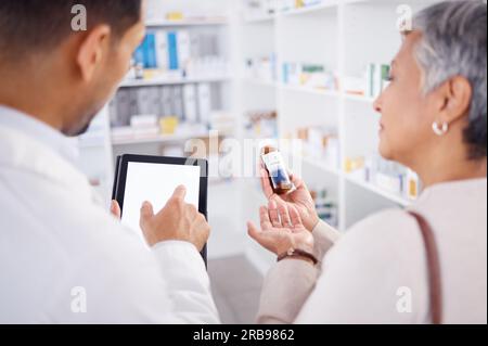 Pharmacien, dactylographie et comprimé avec le client, médicament et question avec discussion pour l'information sur le produit. Homme, patient senior et pilules avec numérique Banque D'Images