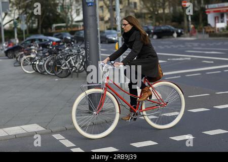 Femme avec une tenue d'affaires sur son vélo se rendre au travail Francfort-sur-le-main, Allemagne Banque D'Images