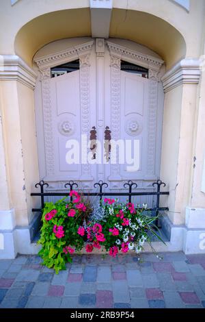 Belle vieille porte en bois blanche décorée de fleurs. Dans la ville lettone de Cesis. Banque D'Images
