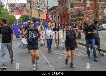 Londres, Royaume-Uni. 8 juillet 2023. Les marcheurs sur Walworth Road en route vers le domaine Aylesbury étaient l’un des 16 à travers le pays à l’occasion de la Journée nationale du logement. Il a exigé que le conseil municipal de Southwark cesse de démolir les maisons du conseil et de rénover et repeupler les domaines pour loger les gens et mettre fin à l'énorme empreinte carbone de la démolition et de la reconstruction. Ils ont exigé des logements pour le besoin et non pour la cupidité des entreprises, la rénovation et non la démolition, le remplissage des maisons vides et la fin du système de bail. Peter Marshall/Alamy Live News Banque D'Images