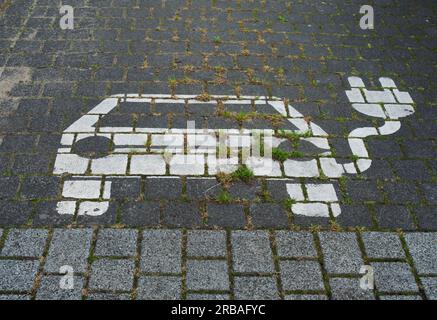 Brême, Allemagne. 03 juillet 2023. 03.07.2023, Brême. Une icône de voiture électrique est visible sur un parking pour charger les batteries à une station de recharge pour e-cars. L'icône en couleur blanche sur le trottoir a un câble et une prise. Crédit : Wolfram Steinberg/dpa crédit : Wolfram Steinberg/dpa/Alamy Live News Banque D'Images