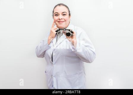 Ophtalmologiste souriant tenant une messbrille isolée. Portrait d'optométriste tenant une lentille de messbrille isolée Banque D'Images