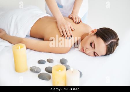 Jeune femme profitant d'un massage relaxant du dos au spa.Soins du corps, concept de repos Banque D'Images