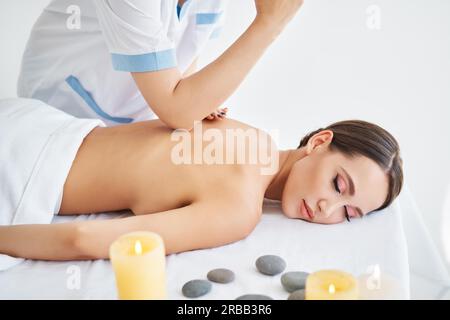 Jeune femme recevant un massage relaxant du dos par un thérapeute professionnel au spa.Soins du corps, concept de repos Banque D'Images