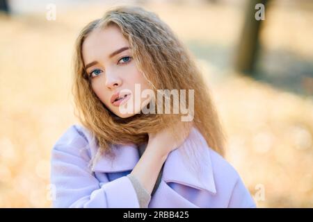 Portrait d'une jolie femme en plein air dans un parc d'automne en profitant d'une journée ensoleillée.Concept de la saison d'automne, beauté féminine Banque D'Images