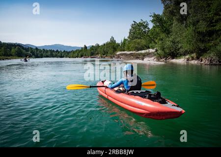 Un garçon pagaie son kayak sur une rivière en haute-Bavière, Isar, Lenggries, Bavière, Allemagne un jour d'été Banque D'Images