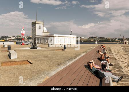 Les gens bronzer sur un banc au phare de Sao Miguel-O-Anjo, image de style vintage, couleurs rétro, Foz do Douro, Porto, Région Norte Banque D'Images