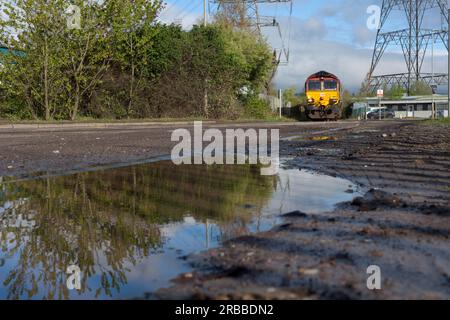 DB Cargo Rail locomotive diesel de classe 66 66053 transportant un train de marchandises transportant de l'acier à Newport docks, au sud du pays de Galles. Banque D'Images