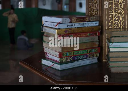 8 juillet 2023. Piles d'Al Qur'an sur étagère en bois à Mesjid Sunan ample ou mosquée Sunan ample à Surabaya, Indonésie Banque D'Images