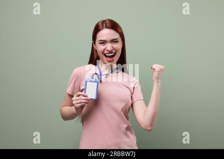 Femme émotionnelle avec badge vip Pass sur fond vert pâle Banque D'Images