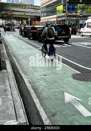 Les banlieues empruntent la piste cyclable sur une rue animée de New York. Banque D'Images