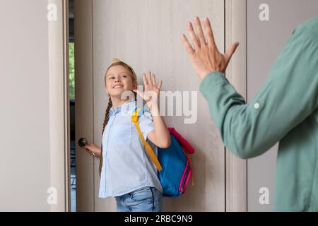 Petite fille disant au revoir à son père avant d'aller à l'école dans le hall Banque D'Images