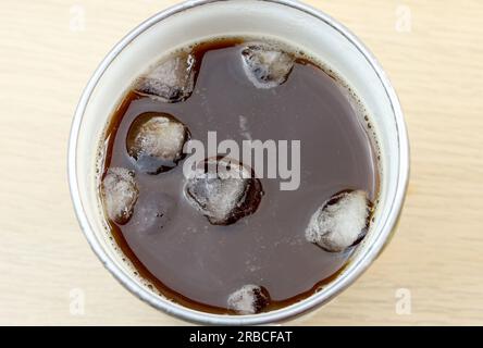 Vue de dessus café noir glacé ou americano avec moins de glace sur la table en bois Banque D'Images