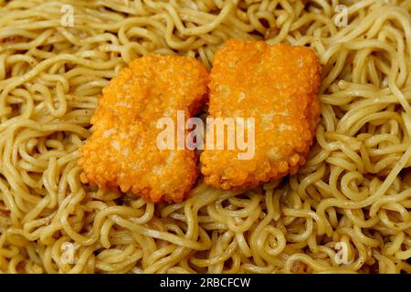 Nouilles cuites sur tout le cadre. gros plan de nouilles délicates avec des nuggets de poulet Banque D'Images