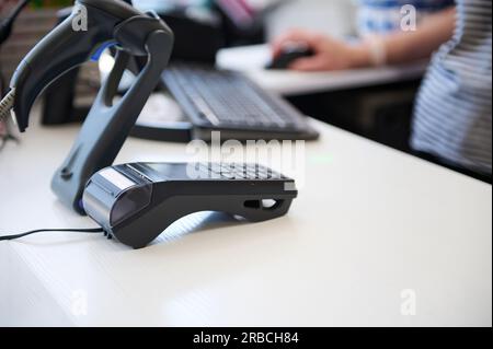 Mise au point sélective. Un comptoir avec lecteur de carte de crédit et lecteur de code-barres dans un magasin. Terminal de point de vente. Technologie NFC. Personnes. Entreprise. Finances. Près de fi Banque D'Images