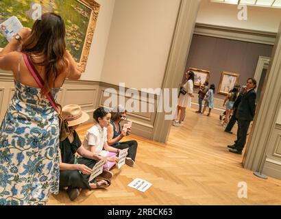 Un visiteur voit une peinture de Claude Monet alors que des militants de extinction Rebellion ont organisé une manifestation de solidarité dans la zone des peintures européennes du Metropolitan Museum of Art à New York le 8 juillet 2023 pour abandonner les charges contre Joanna Smith et Tim Martin Banque D'Images