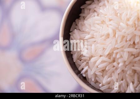 une tasse pleine de riz cru à grains longs sur une table Banque D'Images