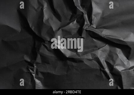 Black wrinkled paper texture in low light background Banque D'Images