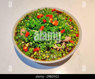 Rein de porc braisé frais avec poireau chinois vert et poivrons rouges dans l'assiette Banque D'Images