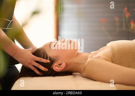 Femme recevant un massage de la tête au salon de beauté Banque D'Images